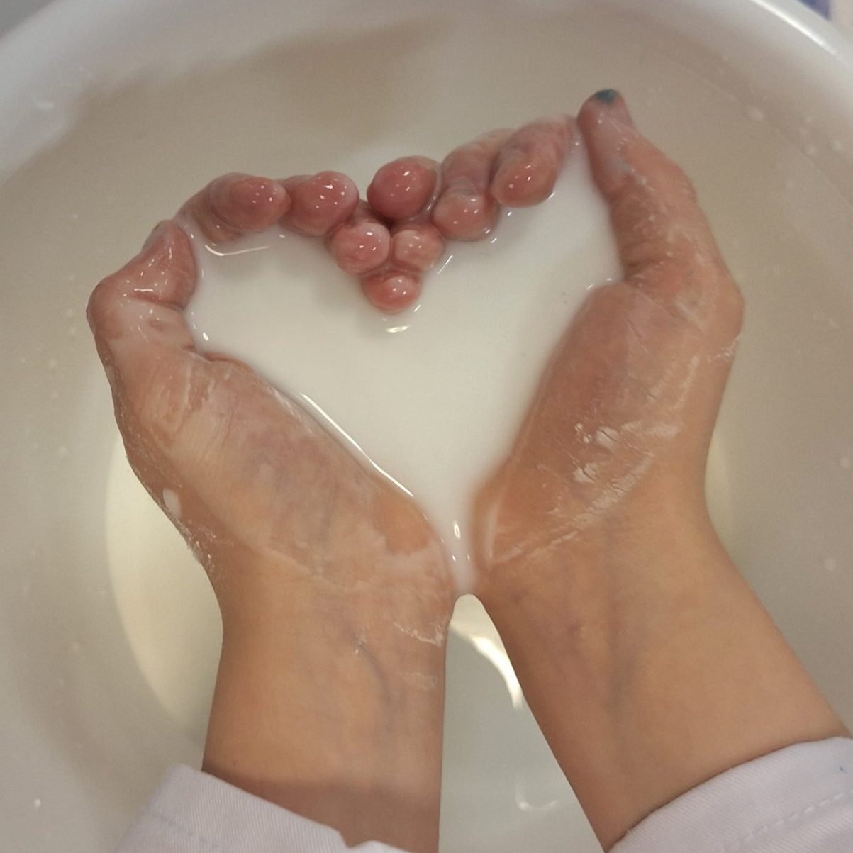 Lapsen kädet, joilla on perunajauhosta ja vedestä valmistettua pilalimaa.