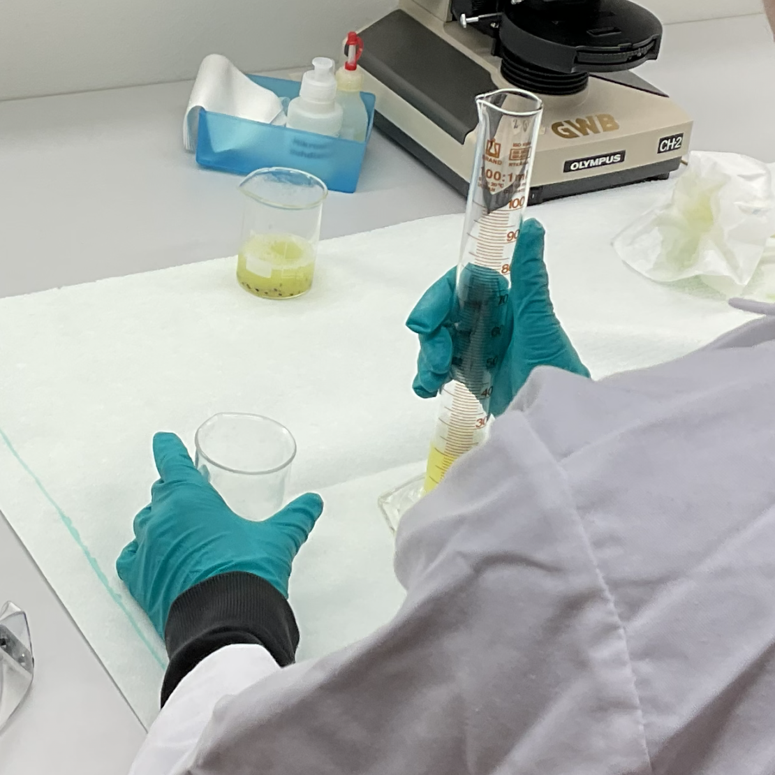 Oppilas laboratoriotutkimusten äärellä laboratoriotakki päällä